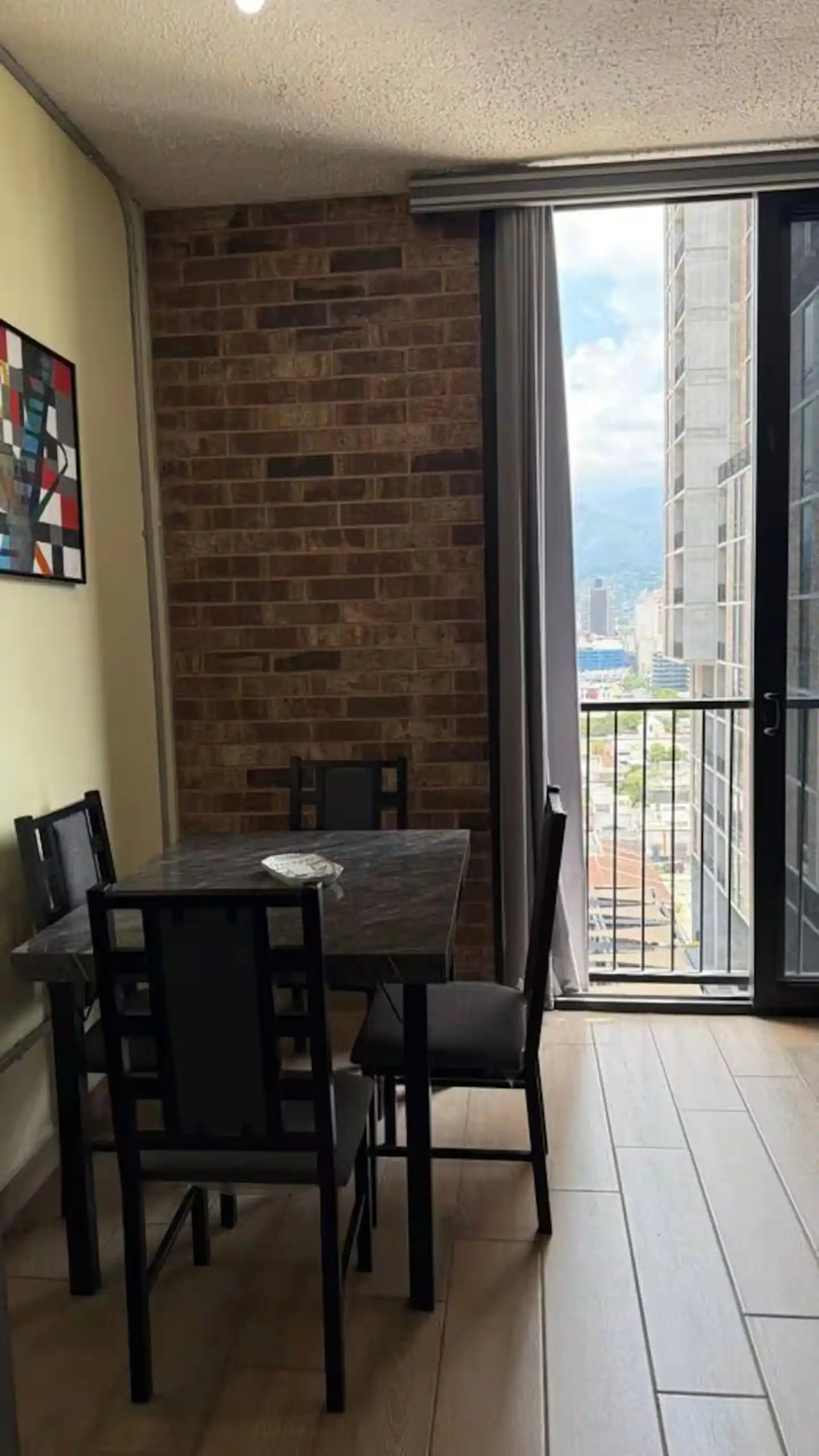 Comedor junto al ventanal, con salida al balcón