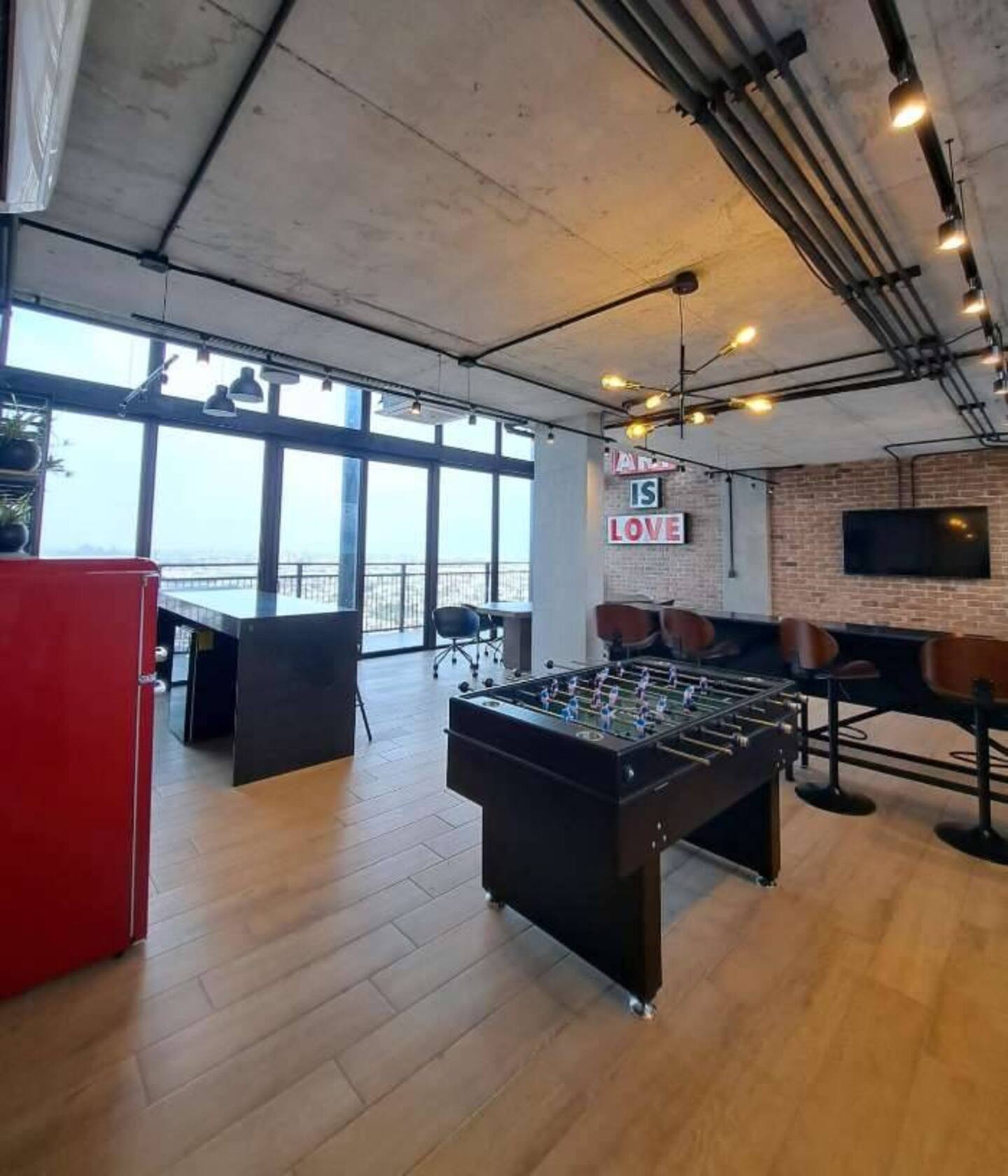 Sala de juegos con futbolito y pantalla