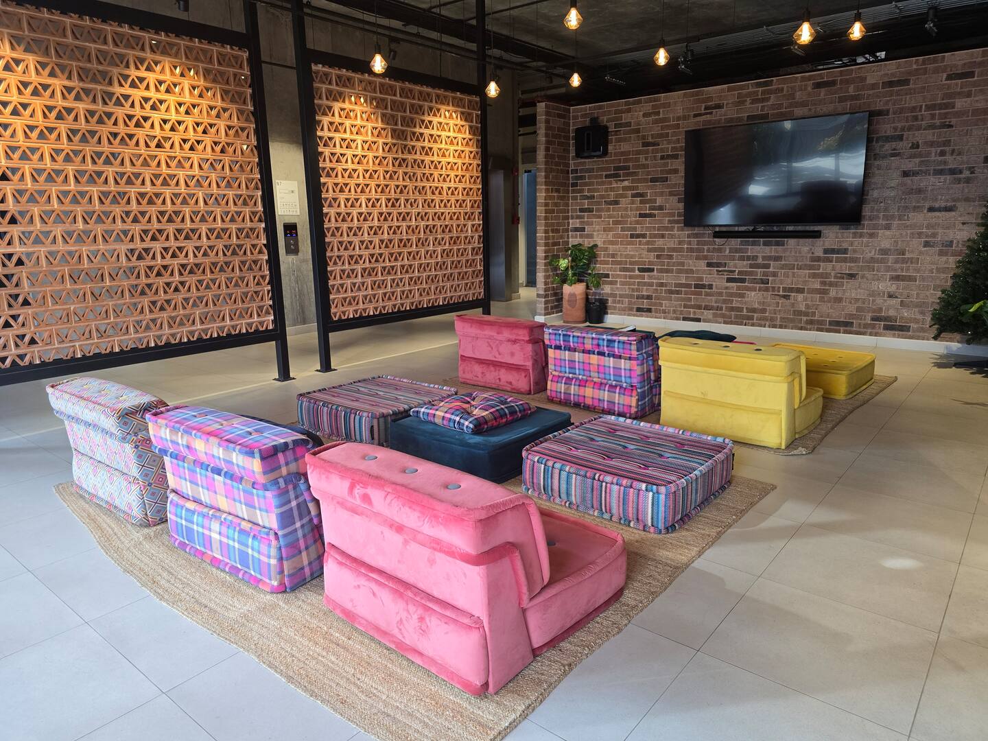 Sala de cine con puffs de colores y pantalla grande